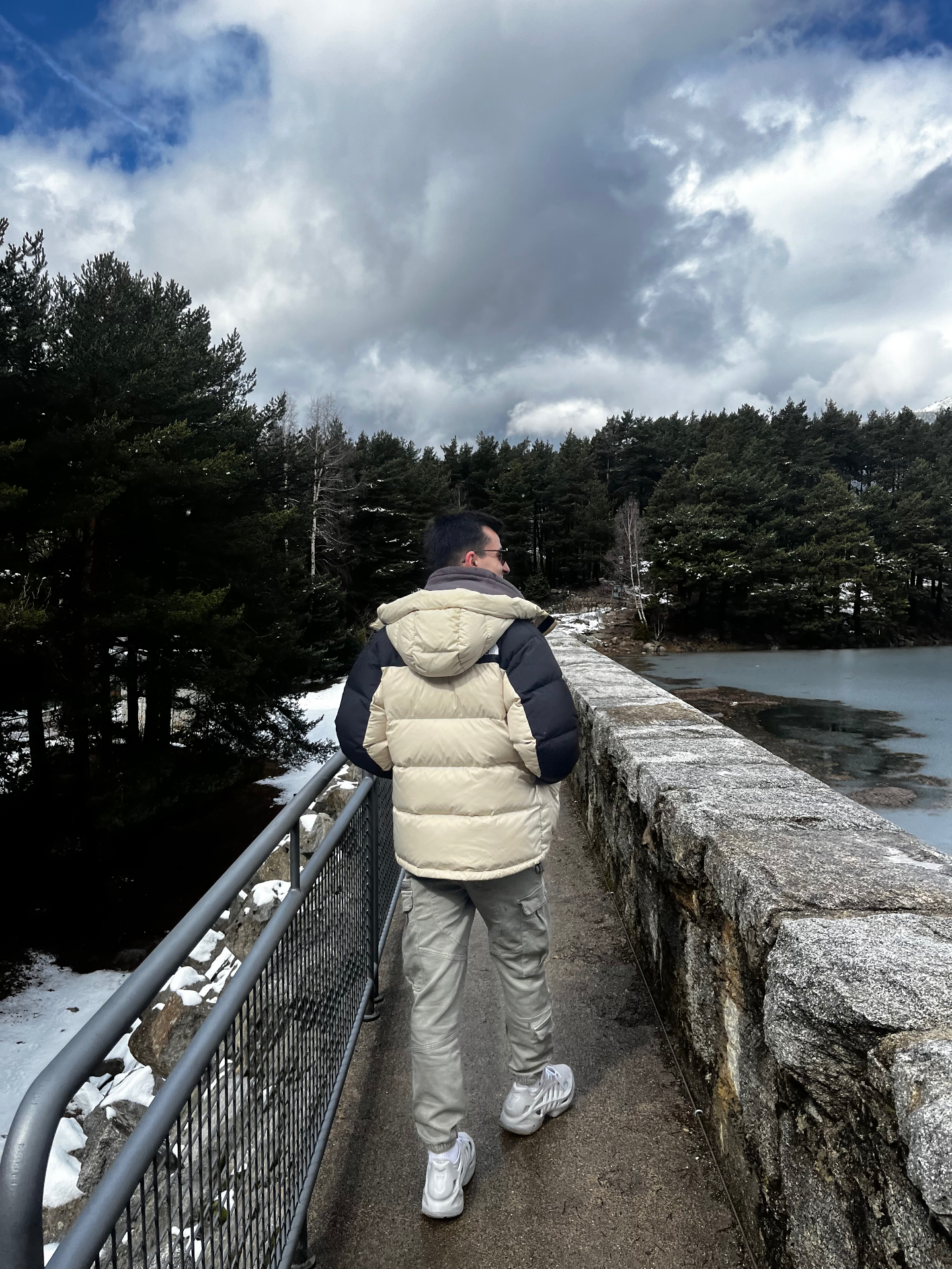 Él cruzando el puente de piedra hacia el bosque