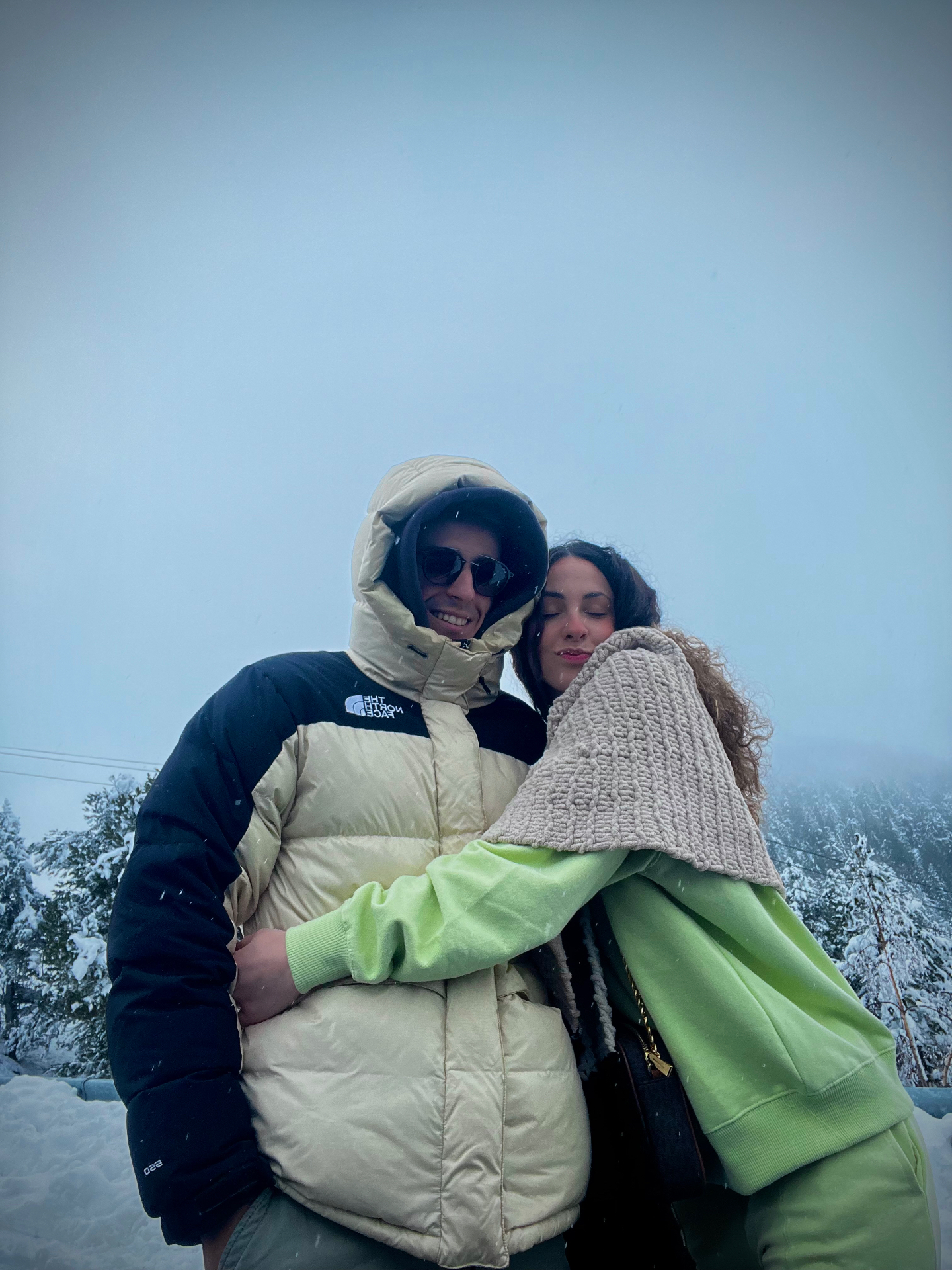 Abrazo en la nieve entre los pinos nevados
