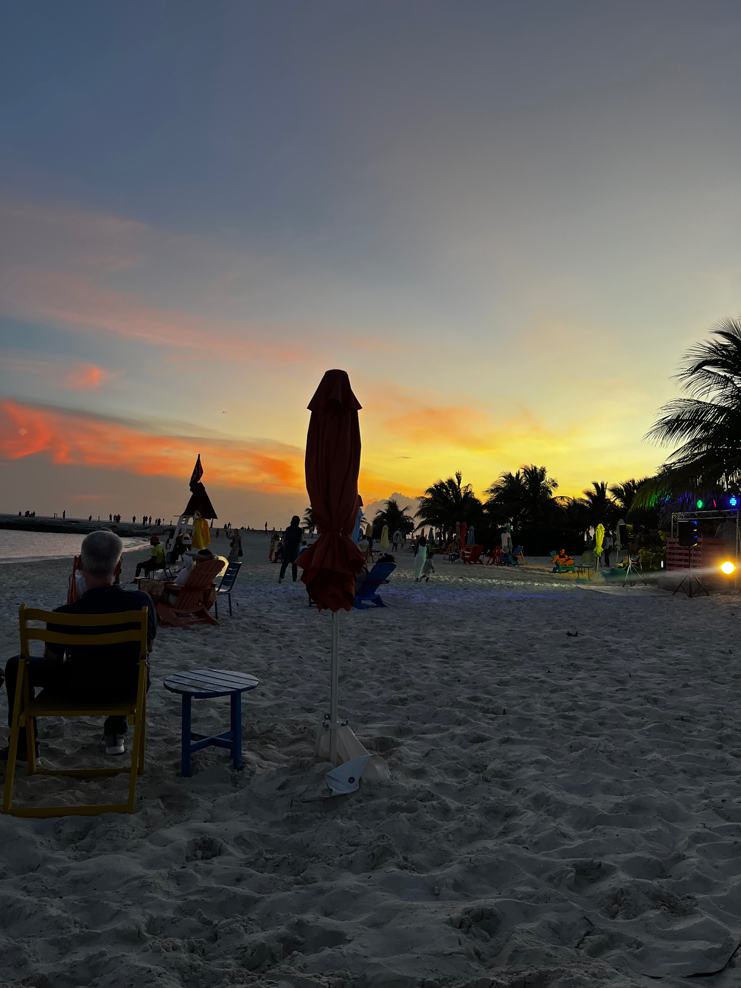 Atardecer en la playa de Ocean Cay con sombrillas, palmeras y cielo encendido