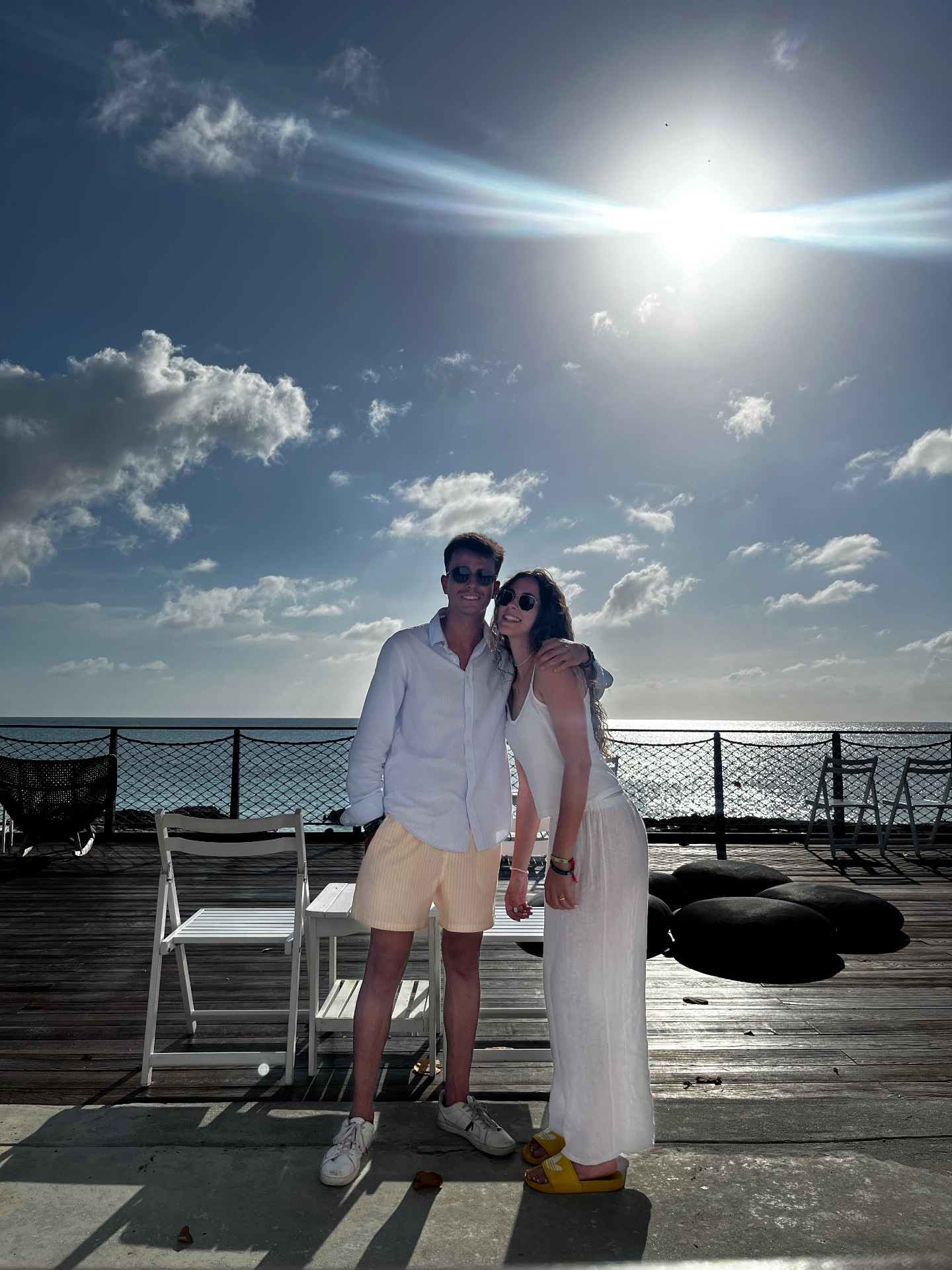 Foto de pareja junto al mar en el muelle de Ocean Cay con el sol de fondo