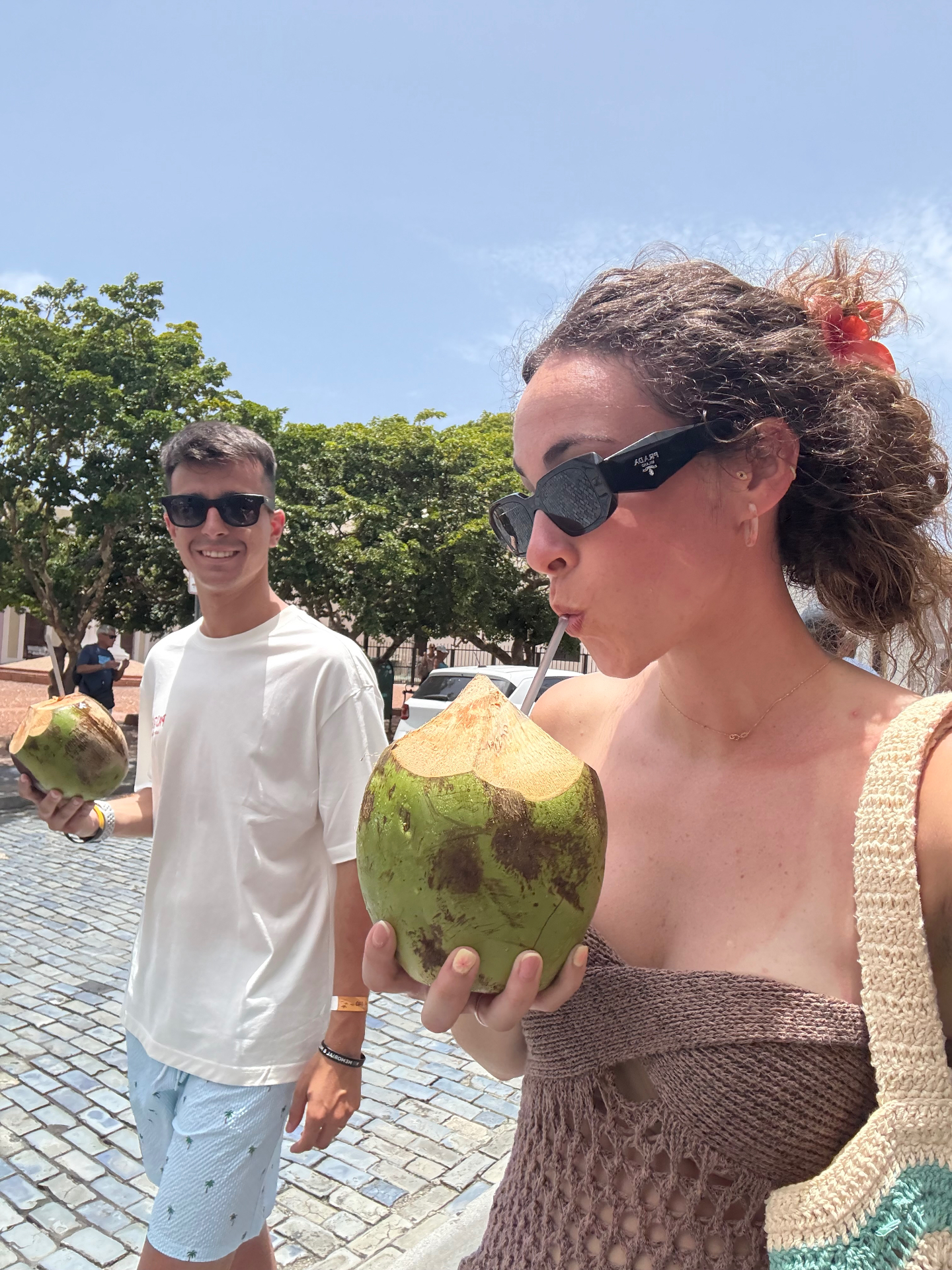 Pareja con cocos recién abiertos por las calles