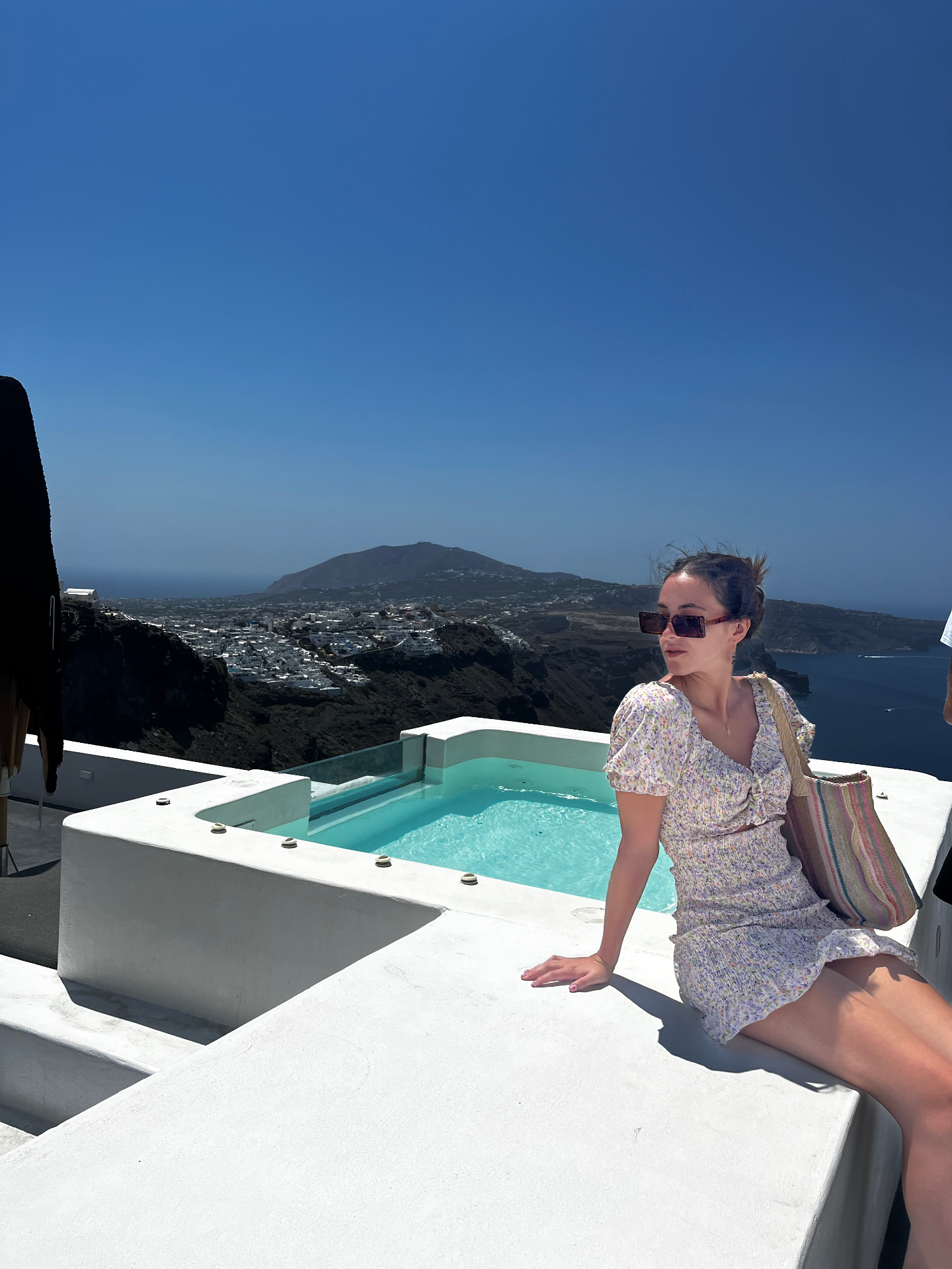 Sentada junto al jacuzzi, Fira al fondo