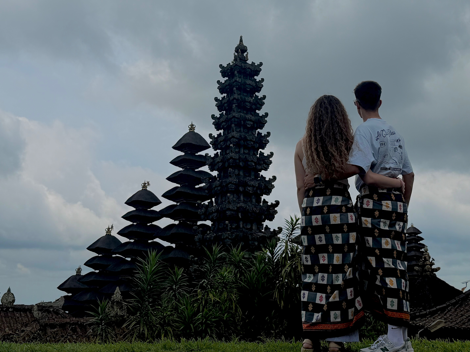 Abrazados con sarong tradicional frente a las pagodas del templo madre de Besakih