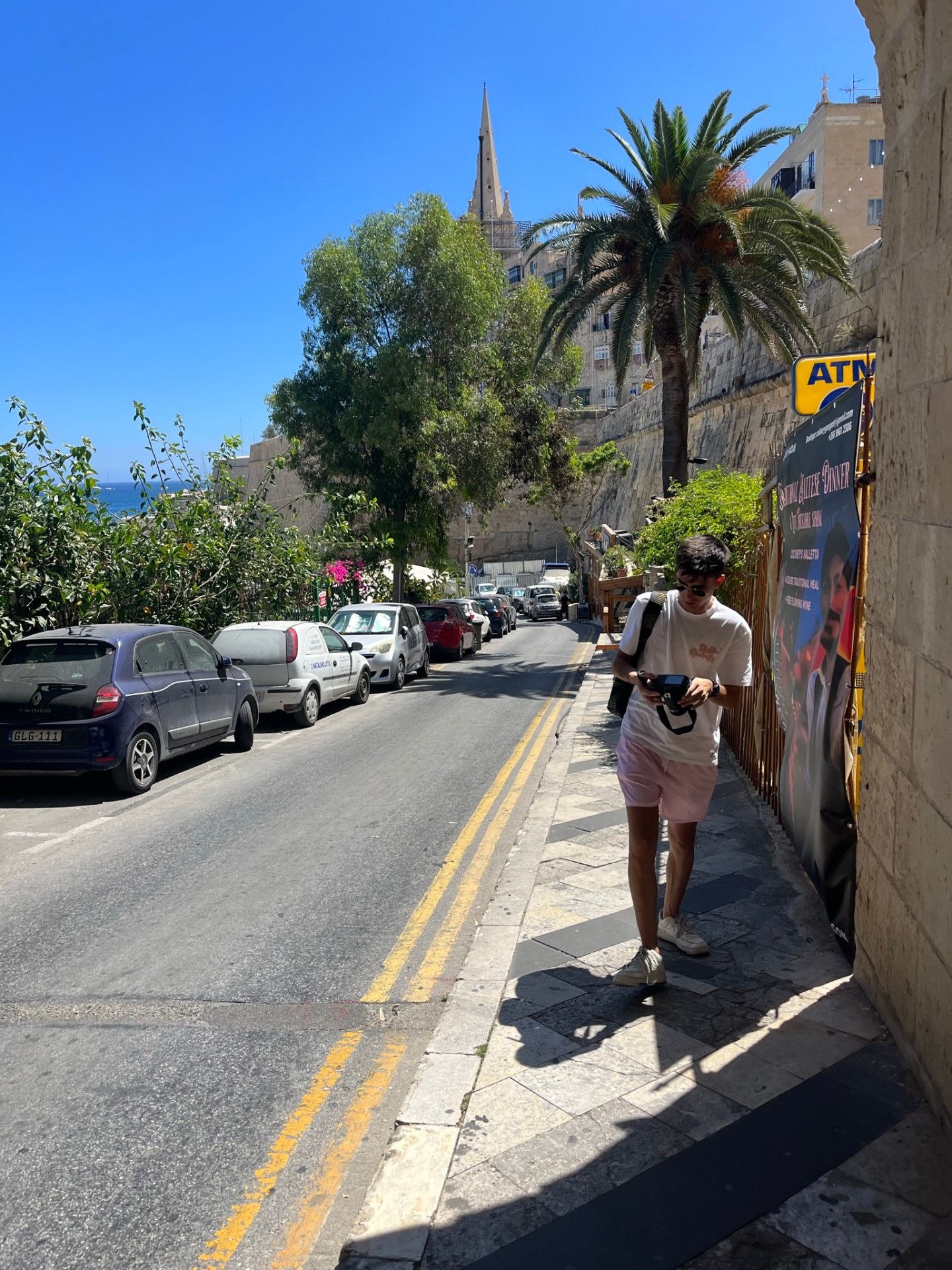 Paseando bajo la palmera con el campanario al fondo
